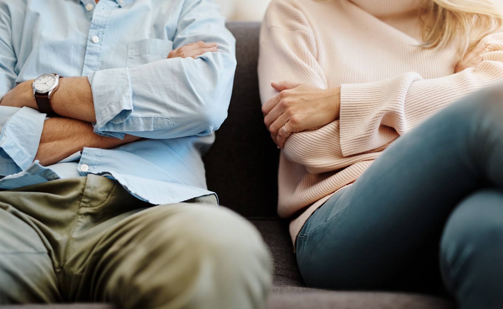 A couple sitting cross armed next to eachother following divorce.