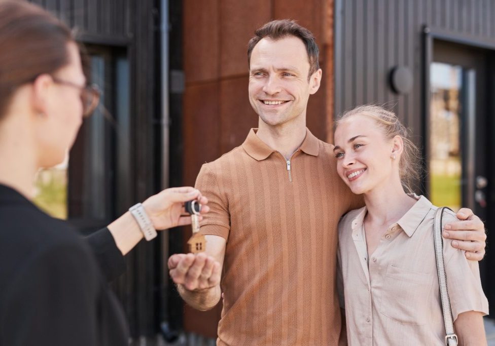 Happy couple receiving the keys to their first home.